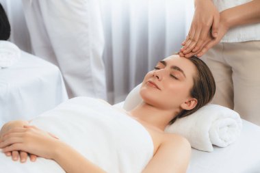 Kafkasyalı kadın stres önleyici kafa masajından ve lüks tatil beldesi ya da otel spa salonundaki modern ışık ortamında yüz güzelliği eğlencelerini şımartmaktan hoşlanıyor. Sessiz.