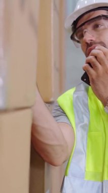Profesyonel kargo işçisi başka bir işçiyle bağlantı kurmak için telsizle konuşuyor. Fabrika ve depo iletişim konsepti .