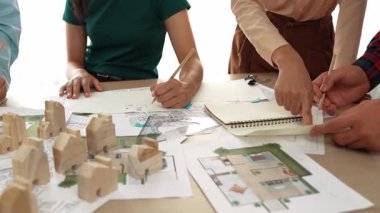 Mimari döküman, ölçüm araçları ve ahşap blokların modern ofiste etrafa saçıldığı masa üzerine planlar yapma konusunda akıllı mimar ve güvenlik mühendisi tartışması. - Yakın çekim. Tanımlama.