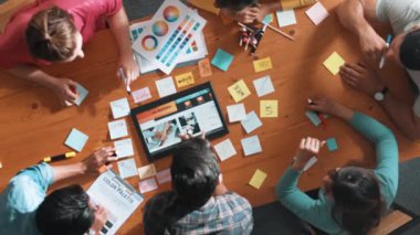 Web tasarımı için birlikte çalışan iş adamlarının üst düzey görüşü. Tasarımcı beyin fırtınası yapan ve web sitesi arayüzü hakkında tartışan ve dijital tasarım ile tablete bakan hava görüşü. Sempozyum.