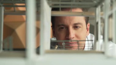 Kafkasyalı mimar mühendisinin yakın çekimi ev inşaatını denetlemek ve bina malzemelerini kontrol etmek. Proje yöneticisi modele dikkatlice bakarken kalemi işaret ediyor. Yönlendirici.