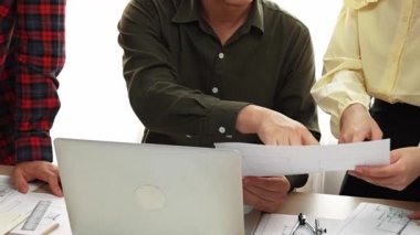 Akıllı mimar ve güvenlik mühendisi, mimari belge, ölçüm araçları ve ahşap blokların modern ofiste etrafa saçıldığı masa planlarını tartışıyor. - Yakın çekim. Tanımlama.