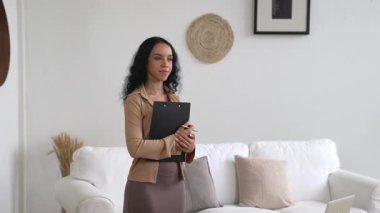Klinikteki psikolog kadın. Profesyonel portresi. Dostane gülümsemesiyle hastayı psikoloğa davet ediyor. Deneyimli ve kendinden emin psikolog çok önemli bir uzmandır.