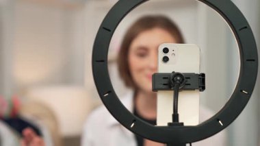 Kadın nüfuzlu kişi video görüntülerini canlı yayınlıyor. Kıyafetler sosyal medyada ya da blogda yer alıyor. Stüdyo ışıklandırmalı mutlu genç kız çevrimiçi pazarlama oturumu yayını için..