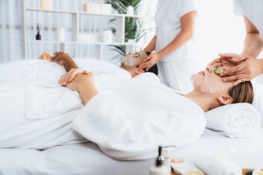 Kaplıca salonunun sakin atmosferi, birkaç müşteri lüks salatalık yüz maskesi takarak kendini yenilemeye çalışıyor. Yüz bakımı tedavisi ve güzellik konsepti. Sessiz.