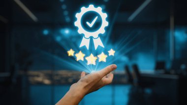 Bir el, modern ofis ortamında kaliteyi ve mükemmelliği simgeleyen, beş yıldız ve bir işaret gösteren dijital bir rozete uzanır. Fütüristik görünüş profesyonelliği temsil ediyor. Auvana