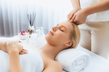 Kafkasyalı kadın stres önleyici kafa masajından ve lüks tatil beldesi ya da otel spa salonundaki modern ışık ortamında yüz güzelliği eğlencelerini şımartmaktan hoşlanıyor. Sessiz.