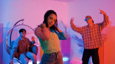 Çekici mutlu dansçı kameraya bakarken zeki kadın neon ışıkla kafiyeli hareket ediyor. Profesyonel İspanyol şarkıcı çeşitli arkadaşlarıyla renkli kıyafetler giyerken break dans yapıyor. Mutluluk.