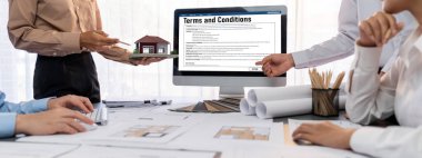 İç mimar tasarımcı grubu, daha kesin tasarım için planlar ve dizüstü bilgisayar ekran mimari yazılımı üzerinde birlikte tartışıyorlar. Modern ev tasarımı ve yenileme. İçgörü