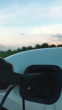 Çevreyi korumak için rüzgar türbininden yeşil ve yenilenebilir enerjiyle çalışan şarj istasyonunda şarj edilen gelişmiş gelecek enerji altyapısı konsepti.