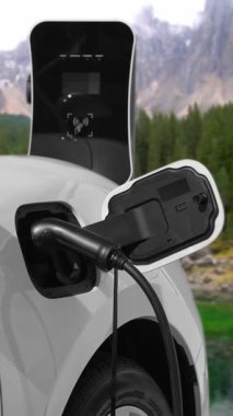 Elektro jeneratör sürücüsüyle enerji sürdürülebilir araba gücü, şarj istasyonunda şarj edilen batarya, ilerici seyahat konsepti için dağ zeminine sahip. Temiz ortamın sembolü olarak doğadaki EV otomobil.