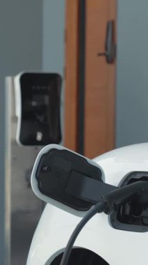 Evinde şarj edilen elektrikli bir araçla işten yeni dönen modern bir kadının ilerici yaşam tarzı. Elektrikli araç, sürdürülebilir temiz enerjiyle çalışıyor..