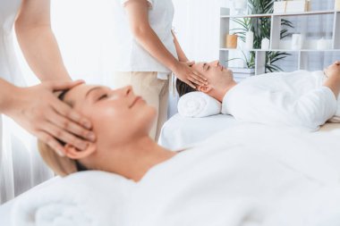 Kafkasyalı çift stres önleyici kafa masajının keyfini çıkarıyor ve lüks otellerde ya da otel spa salonlarında gündüz kaplıcalarında yüz güzelliği eğlencelerini şımartıyor. Sessiz.