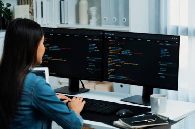 İnternet sitesi uygulamasının kodlama verileriyle birlikte online bilgi yazarak kot gömlek giyen genç Asyalı geliştirici. Güvenlik analizi ile çevrili iki ekran. Taktik.