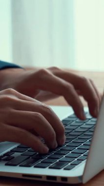 İşadamı ofis masasındaki becerikli dizüstü bilgisayarda elle çalışıyor. Bilgisayarın klavyesini yazarken ve çalışırken yakın çekim ve seçici odaklanma.