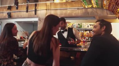 Lüks bir barda VIP müşterisi olan zeki bir barmen sıcak bir gece kulübünün ışıklandırma atmosferinde canlı bir sohbet için tezgahta yeni ve güzel bir konuğu selamlıyor. Vinosity.