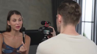 Erkek arkadaşı ya da kameramanı canlı yayın ekipmanıyla güzellik ve kozmetik dersi veren genç bir kadını filme alıyor. Güzellik blogcusu sosyal medya izleyicilerine ya da takipçilerine güzellik videosu yapıyor. Düzenle