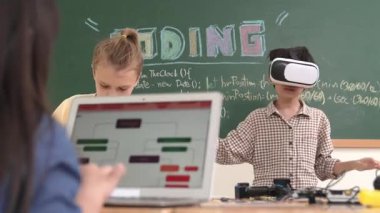 VR kulaklık takan enerjik bir çocuk sınıfta sanal dünyaya giriyor. Öğrenci programlama sistemi, çocuk elektronik panoyu tamir ederken yapay zeka ile mühendislik komut yazılımı oluşturdu. Pedagoji.