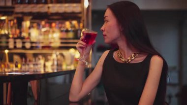 Cosmopolitan kırmızı kokteylinde tek başına güzel bir şekilde oturup arkadaşlarınızı ya da Bokeh 'te bir çifti beklemek cuma gecesi barda ve restoranda lüks bir içki tezgahı yakmak. Vinosity.