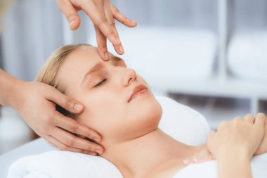 Kafkasyalı kadın stres önleyici kafa masajından ve lüks tatil beldesi ya da otel spa salonundaki modern ışık ortamında yüz güzelliği eğlencelerini şımartmaktan hoşlanıyor. Sessiz.