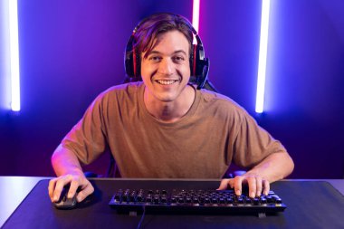 Kazanmak için çevrimiçi oyun oynayan akıllı flama makinesinin sunucu kanalı, neon ışıklı odada seçilen takım yarışması için izleyicilerle birlikte canlı yayında canlı yayında kulaklık takıyor. Bireysel.