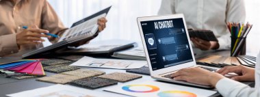 Masadaki bir grup iç mimar dizayn ekibi dizüstü bilgisayarında mimari yazılımı olan renk örnekleri seçiyor. Modern ev yenileme ve iç renk seçim konsepti. İçgörü