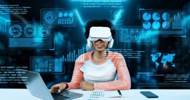 Masada kitap ve dizüstü bilgisayarla ödev yaparken metaevreleri birbirine bağlayan dizüstü bilgisayar ve artırılmış gözlük kullanan bir kız. Öğrenci holograma bakıyor ve yapay zekayı kullanıyor. Yaratıcılık.