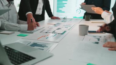 Çeşitli bir iş ekibi modern ofis ortamında iş birliği yapıyor. Stratejik büyüme ve etkili iletişim odaklı finansal raporlar ve veri tablolarını analiz ediyorlar. SACTR