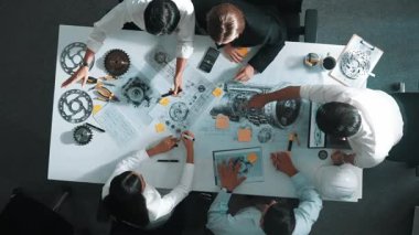 Mühendisin, toplantı masasındaki türbin motorunu ekipmanla gösteren üst düzey görüntüsü. Profesyonel proje yöneticisinin elektronik jeneratör sistemi hakkında konuştuğu ve tartıştığı hava görüntüsü. Hizalama.