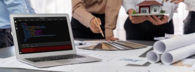 İç mimar tasarımcı grubu, daha kesin tasarım için planlar ve dizüstü bilgisayar ekran mimari yazılımı üzerinde birlikte tartışıyorlar. Modern ev tasarımı ve yenileme. İçgörü