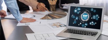 İç mimar tasarımcı grubu, daha kesin tasarım için planlar ve dizüstü bilgisayar ekran mimari yazılımı üzerinde birlikte tartışıyorlar. Modern ev tasarımı ve yenileme. İçgörü