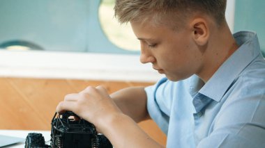 Genç öğrenciye yakın çekim tornavida kullanarak fındığı sıkılaştır. BTMM teknoloji sınıfında robot makine yapımını incelerken, beyaz tenli bir genç araba modelini tamir ediyor ya da onarıyor. Öğretim.