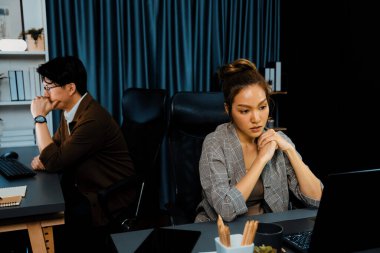 Modern ofiste gece geç saatlerde arka tarafta çalışan iş arkadaşı ile birlikte veri analizi sosyal medya çevrimiçi proje işini rapor etmek için bilgisayara odaklanan iş kadınının ciddi yüzü. İnfobahn.