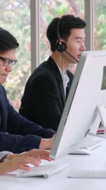 Ofiste çalışan kulaklık takan işadamları uzak müşteri ya da meslektaşlarını desteklemek için çalışıyorlar. Arama merkezi, tele pazarlama, müşteri destek acentesi telefon görüşmesinde hizmet sunar.