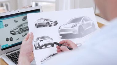 Araba tasarım mühendisi otomobil işi için otomobil prototipini ev ofisinde analiz ediyor. Otomotiv mühendisliği tasarımcısı dikkatle analiz eder, kusurları bulur ve dizüstü bilgisayarla araba tasarımında gelişmeler kaydeder.