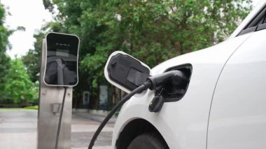 Elektrikli araba parkı ve şarj istasyonunun yanında şarj edilen enerji konseptinin sürdürülebilirliği. Çevresel koruma için yenilenebilir enerji tarafından kullanılan elektrikli araç.