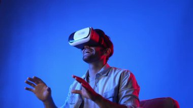 VR gözlük takan zeki bir adam ve metaevrene girmek için heyecanlı. Çekici oyuncu sanal gerçeklik dünyasını bağlarken ve hareket ederken veya etrafa bakarken fantezi oyunu oynuyor. Eğlence için. Aygıt.