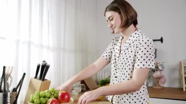 Çekici beyaz anne salata yapmak için taze sebze doğruyor. Mutlu enerjik akıllı anne kahvaltıda sağlıklı yemek pişirirken modern mutfakta çalışıyor. Yemek hazırlama konsepti. Pedagoji.