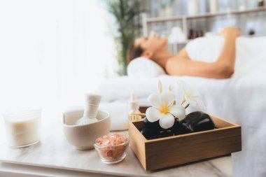 Aromaterapi masajı gündüz atmosferinde ya da spa salonunda bulanık bir kadına odak dekor ve spa aksesuarları kurarak tatil köyünde ya da otel arka planında keyifli aroma spa masajı yapan bir masaj. Sessiz.