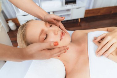 Kafkasyalı kadın stres önleyici kafa masajından ve lüks tatil beldesi ya da otel spa salonundaki modern ışık ortamında yüz güzelliği eğlencelerini şımartmaktan hoşlanıyor. Sessiz.