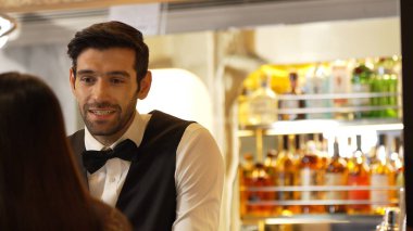 Gülümseyen zeki barmen, gece kulübünde VIP müşterilerle canlı sohbetler yapmak için güzel bir gece partisi atmosferine mükemmel bir servis sunuyor. Vinosity.