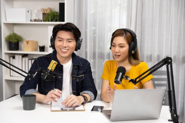 Gülümseyen radyo etkili sunucular, kulaklık takarak sosyal medya kanalından canlı yayın yapıyorlar ve sabah saatlerinde stüdyo kaydında dinleyicilere konu ve dizüstü bilgisayar üzerinden konuşuyorlar. İnfobahn.