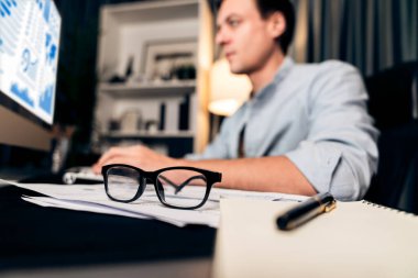 Akıllı işadamı klavyesini monitörde, iş paragrafı dinamik veri pazarlama analizi tablosu ile birlikte gece vakti modern merkez büroda rapor evrakları üzerinde daktilo ediyor. Bireysel.