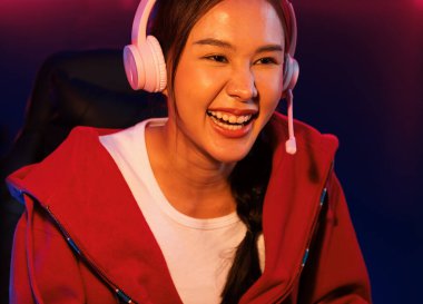 Portre sunucusu güzel Asyalı kız flamasının çevrimiçi oyun oynaması kulaklık takması pastel renkli konuşmalar izleyici medyası ile çevrimiçi. Esport yetenekli takım oyuncuları neon mavi odada. Taktik.