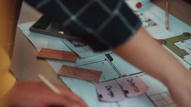 Ev yenileme projesi sırasında rengarenk fayanslar ve malzemelerle etkileşen ellerin yakın çekim görüntüsü, iç tasarımda yer alan yaratıcılığı ve planlamayı gözler önüne seriyor. SACTR