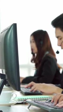 Ofiste çalışan kulaklık takan işadamları uzak müşteri ya da meslektaşlarını desteklemek için çalışıyorlar. Arama merkezi, tele pazarlama, müşteri destek acentesi telefon görüşmesinde hizmet sunar.