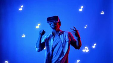 Mutlu dansçı VR gözlük takıyor ve havada süzülen notalarla şarkıya geçiyor. Dans ederken ve hareketli adımlar atarken sanal gerçeklik kulaklığı kullanan çekici bir adam. Aygıt.