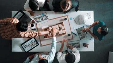 Akıllı yöneticilerin el çırpışları ve projeyi kutlamak için el ele tutuşmaları. İç yapı hakkında beyin fırtınası yapan mimar mühendisinin hava görüntüsü. Takım çalışması, birlik. Hizalama.