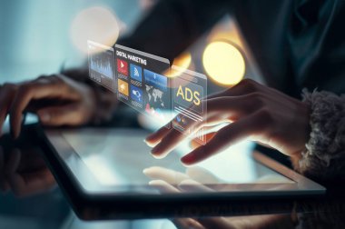 Modern sosyal medya stratejileri ve teknolojilerini vurgulayarak, dinamik dijital pazarlama reklamlarını gösteren yenilikçi bir tabletle ellerin etkileşimine yakından bir bakış. XDMCP