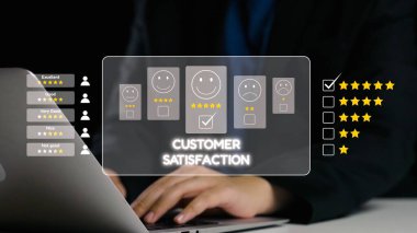 Şirket ortamında dizüstü bilgisayar ekranında gösterilen gülen yüzler ve yıldız reytingleri kullanarak müşteri memnuniyet ölçülerini değerlendiren profesyonel bir görüşe yakın çekim. Dörtgen